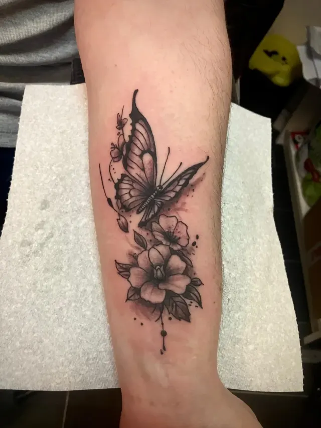 Black and grey butterfly and flowers forearm tattoo with fine shading, N9 Tattoo, Enfield