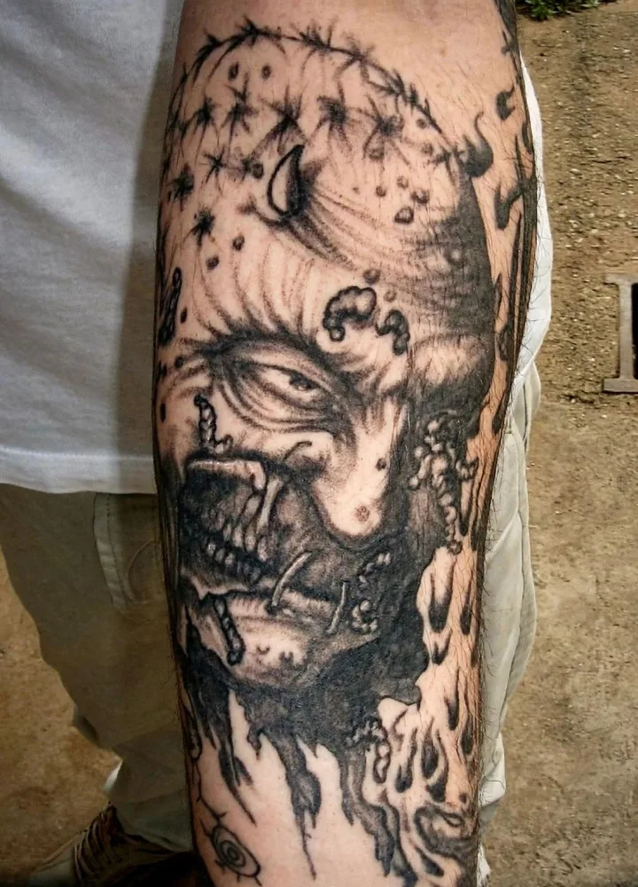 Dark art black and grey forearm tattoo of a grim horned demon face with barbed wire and macabre decay, horror style, N9 Tattoo, Edmonton, North London